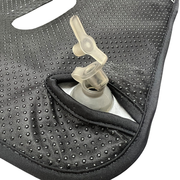 Nahaufnahme eines gepunkteten schwarzen Gewebes mit einer transparenten Kunststoffdüse in einer Öffnung.
