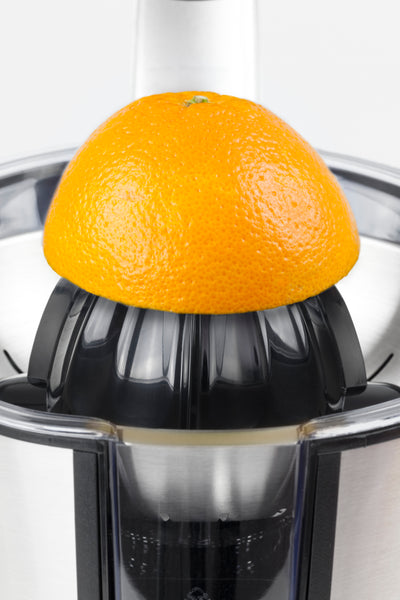 Eine halbe Orange auf einer modernen Zitruspresse  bereit zum Auspressen.
