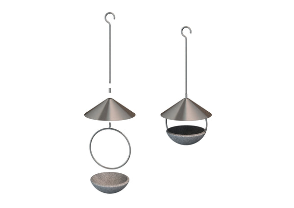 Zwei kleine Vögel sitzen auf einem modernen  hängenden Vogelhäuschen aus Metall mit einem kegelförmigen Dach  vor einem unscharfen Hintergrund aus Ästen und Himmel.
