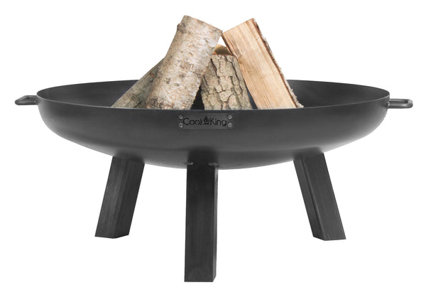 Eine schwarze Feuerschale mit drei Beinen  die einige Holzscheite im Inneren enthält.

