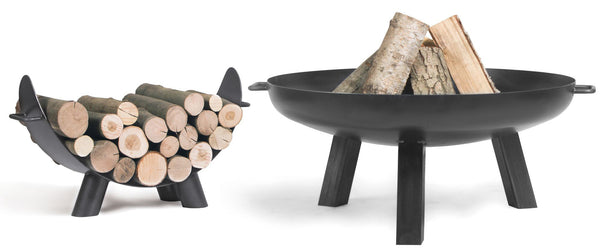 Ein kugelförmiger  schwarzer Feuerkorb  mit Holz innen und einem Holzlager daneben vor weißem Hintergrund.
