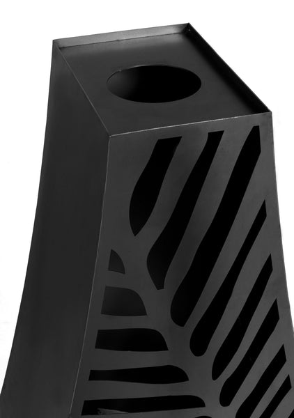 Ein schwarzer  geometrisch geformter Behälter mit runden und geschwungenen Ausschnitten auf der Oberfläche.
