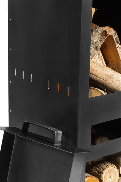 Ein moderner schwarzer Holzofen mit einem Ablagefach  das mit Holzscheiten gefüllt ist  und einem Griff an der Vorderseite.
