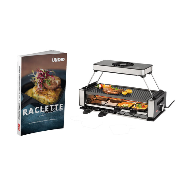 Ein Raclette-Grill mit mehreren Pfännchen und einer Grillplatte mit Gemüse und Fleischstücken  daneben ein Kochbuch mit dem Titel "Raclette Deluxe".
