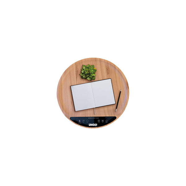 Ein runder Holztisch mit schwarzen Beinen  auf dem ein aufgeschlagenes Notizbuch und eine Brille liegen.
