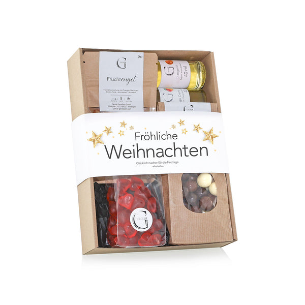 Eine Geschenkbox mit der Aufschrift "Fröhliche Weihnachten"  gefüllt mit verschiedenen Produkten wie Fruchtgummis  Schokoladenkugeln und kleinen Flaschen  dekoriert mit goldenen Sternen.
