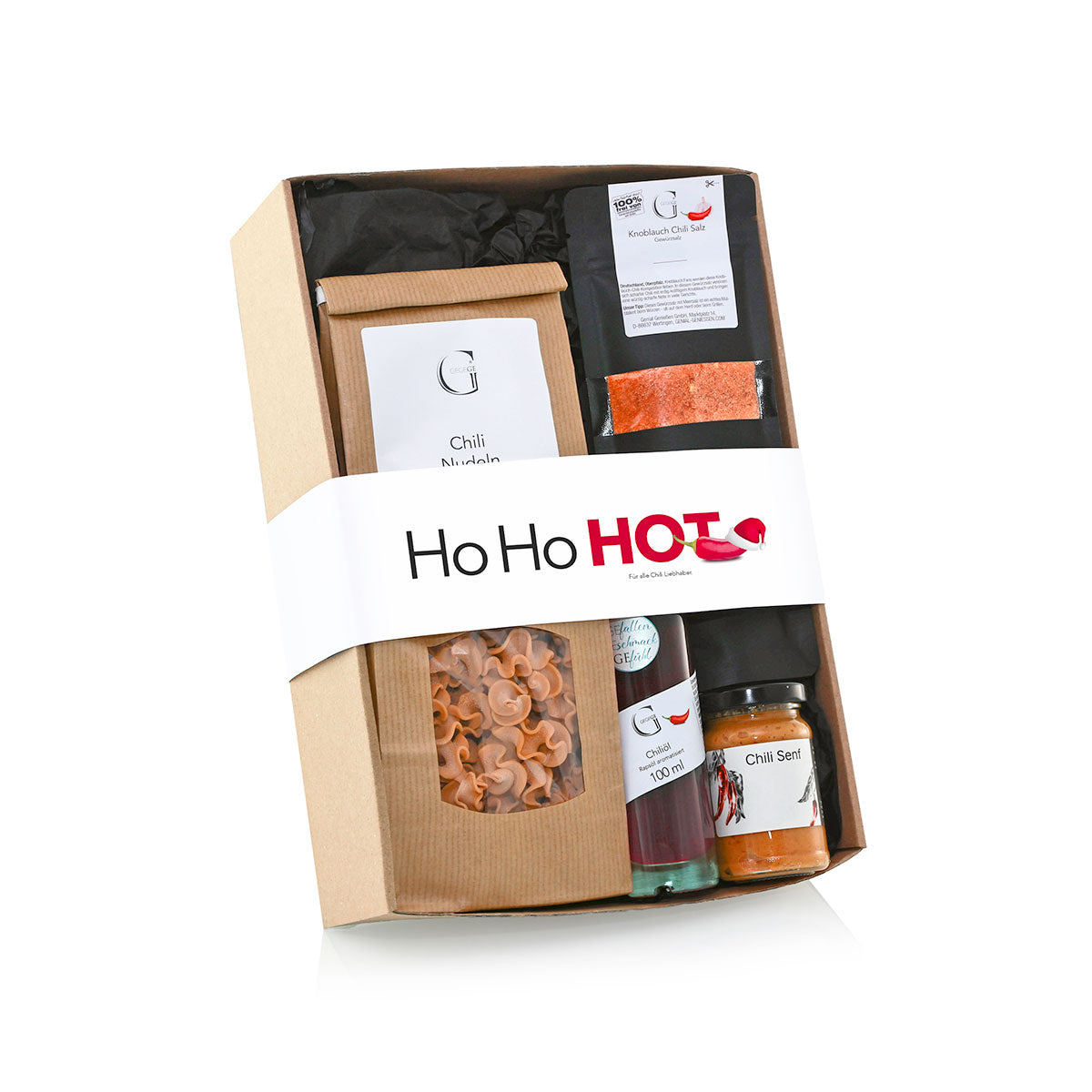 Ein Geschenkkarton mit einer Auswahl an Chili-Produkten  darunter Nudeln  Gewürze und Soßen  sowie ein weißes Band mit der Aufschrift Ho Ho HOT.
