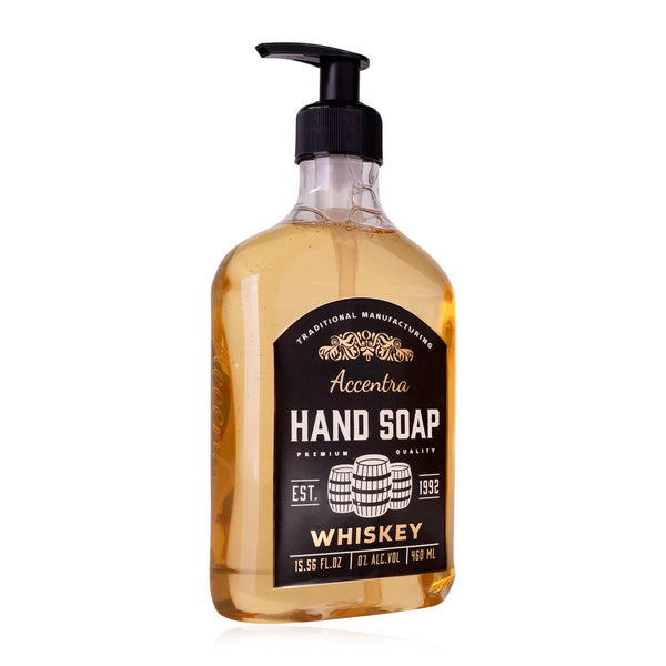 Eine transparente Kunststoffflasche mit einem schwarzen Pumpverschluss  enthält bernsteinfarbene Flüssigseife  etikettiert mit der Aufschrift "Accentra Hand Soap Whiskey".
