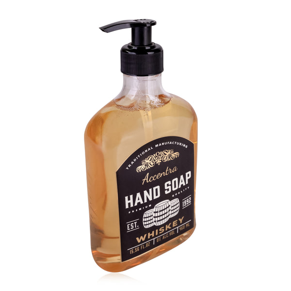 Transparente Kunststoffflasche mit einem schwarzen Pumpkopf  gefüllt mit bernsteinfarbener Flüssigseife  etikettiert als "Accentra Hand Soap - Whiskey".
