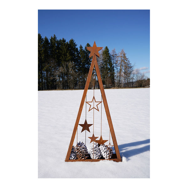 Eine dreieckige Metallskulptur mit hängenden Sternen steht auf einer schneebedeckten Wiese  umgeben von Bäumen im Hintergrund.
