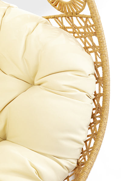 Nahaufnahme eines beigen getufteten Kissens auf einem Hängesessel im Boho-Stil aus strapazierfähigem Polyrattan mit kreisförmig gewebtem Design.