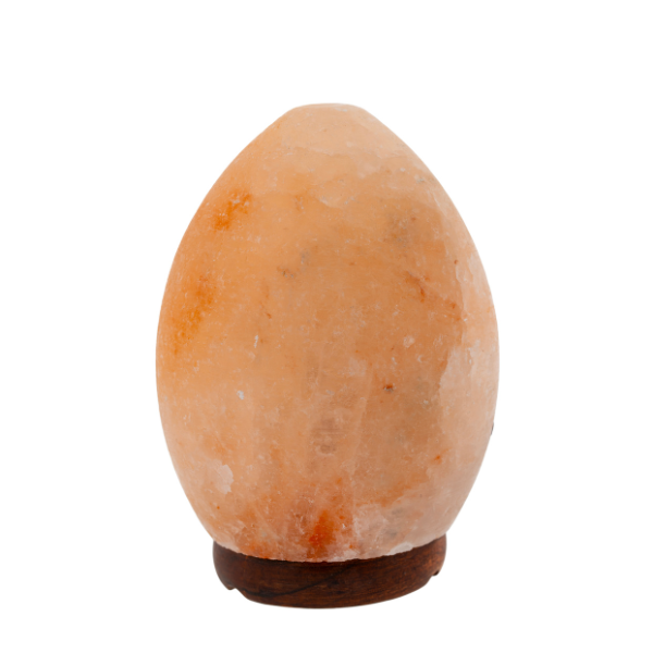 Eine ovale Salzlampe aus rötlich-weißem Salzkristall auf einem kleinen  dunklen Holzsockel.
