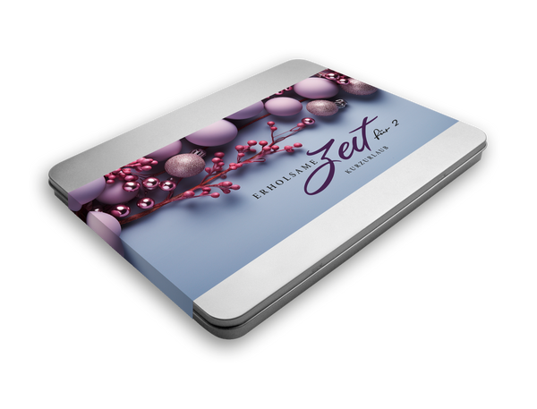 Metallbox mit einem Deckel, auf dem ein lila-blaues Design mit Weihnachtskugeln und Beeren sowie dem Text "Erholsame Zeit für 2 – Kurzurlaub" abgebildet ist