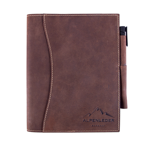 Braunes Ledernotizbuch aus hochwertigem Büffelleder, pflanzlich gegerbt und schadstofffrei, mit genähten Kanten, einem Stift im Halter und geprägtem ALPENLEDER GERMANY-Logo.