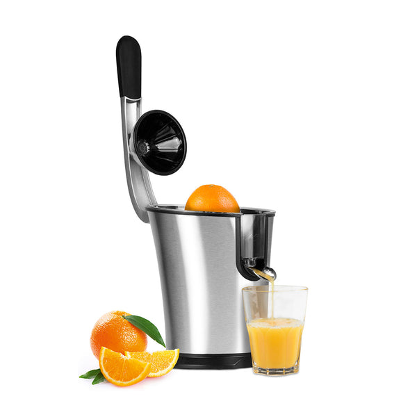 Eine silberne elektrische Saftpresse mit Hebel presst Orangen  neben der ein halbes Glas frischer Orangensaft und geschnittene Orangen liegen.

