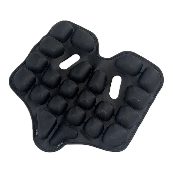 Ein schwarzes  gepolstertes Sitzkissen mit erhabenen  abgerundeten Noppen und zwei länglichen Schlitzen in der Mitte.
