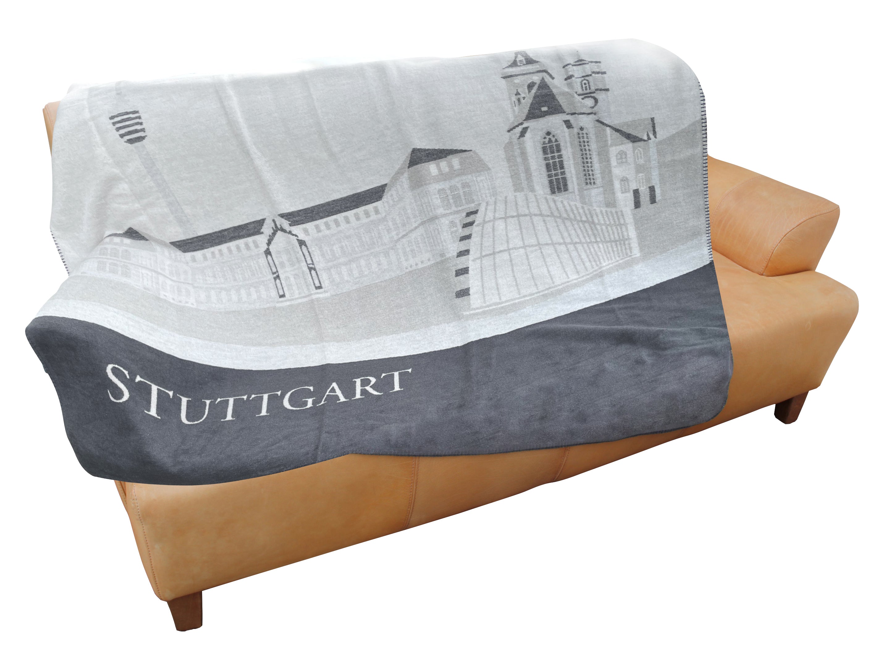 Graue Kuscheldecke mit Stuttgart-Panorama und Schriftzug STUTTGART, gefertigt nach Ökotex-Standard 100, drapiert über einem hellbraunen Sofa.