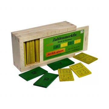 Holzbox mit beschriftetem Schiebedeckel, darin außen grün-gelbe Zahlenmerkfix-Zahlen- und Punktplättchen verteilt, ideal zum Konzentrieren und Üben der Addition.