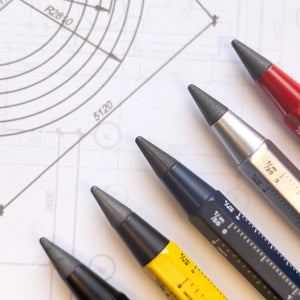 Fünf technische Stifte in unterschiedlichen Farben ruhen auf einer technischen Zeichnung mit Maßangaben und Kreislinien und erzeugen so einen echten BAU-Look. Ideal für Präzisionsarbeiten bieten sie die Zuverlässigkeit einer nachhaltigen Endlosschreibspitze.