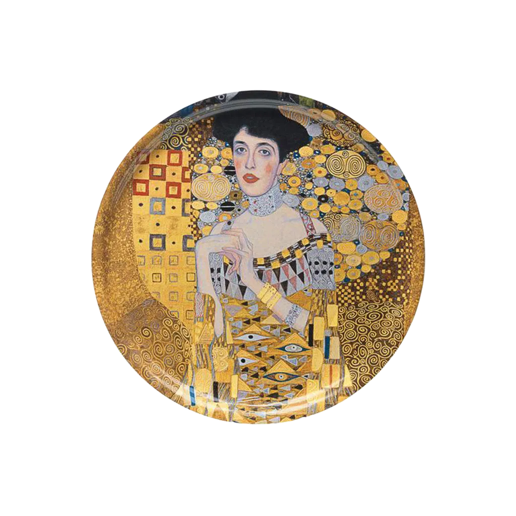 Eine Frau in einem goldgemusterten Kleid sitzt neben einem Holztablett "Adele Bloch-Bauer".