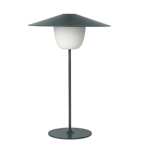 Moderne Tischleuchte mit breitem, flachem, dunklem Schirm und einer weißen, abgerundeten Glühbirne auf schlankem, dunklem Standfuß. Als mobile LED-Leuchte ist sie spritzwassergeschützt und somit flexibel im Innen- und Außenbereich einsetzbar.