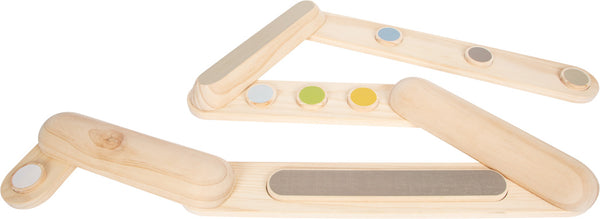 Sensorische Holztafeln mit farbigen und strukturierten Kreisen helfen bei der Entwicklung des Gleichgewichtssinns, während Kinder Balancierpfade auf weißem Hintergrund erkunden.