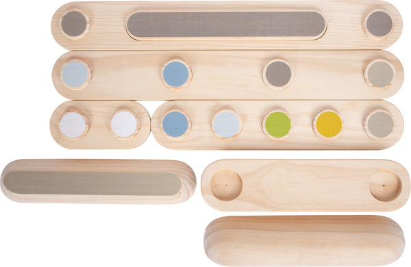 Hölzerne Sinnes-Klangbausteine mit farbigen Kreisen und strukturierten Oberflächen, ideal zum Bauen von Balancierpfaden zur Förderung des Gleichgewichtssinns und Stärkung des Gleichgewichtssinns, angeordnet auf weißem Untergrund.