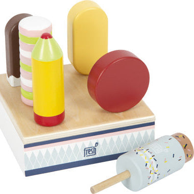 Desserts aus Holzspielzeug, darunter Stieleis und Kekse, auf einer quadratischen Schachtel mit einem geometrischen Muster in Pastellfarben – perfekt für jedes Kinderküchen- oder Eisständer-Spielset.