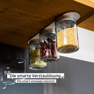 Drei Gläser mit Gewürzen sind als clevere Staulösung mittels Magnetkraft kopfüber unter einem Holzregal befestigt.
