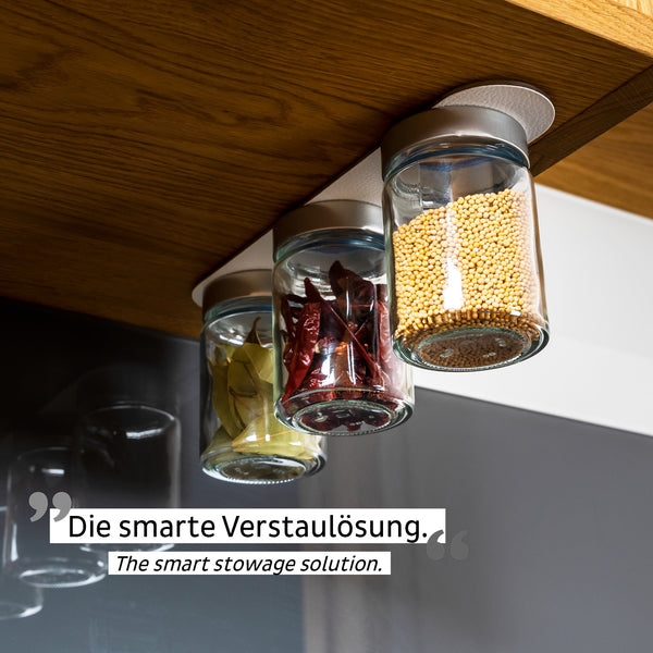 Drei Gläser mit Gewürzen sind als clevere Staulösung mittels Magnetkraft kopfüber unter einem Holzregal befestigt.