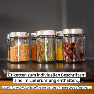 Vier Gläser mit silbernen Deckeln, gefüllt mit Senfkörnern, Gewürzen und Chilischoten, stehen als stilvolle Staulösung mit Magnetkraft ordentlich auf der Küchenarbeitsplatte.