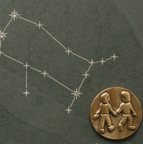 Sternbild Zwillinge mit einem goldenen Medaillon zweier sich an den Händen haltender Figuren, verziert mit Swarovski-Elementen  – ein elegantes Sternzeichen-Andenken.