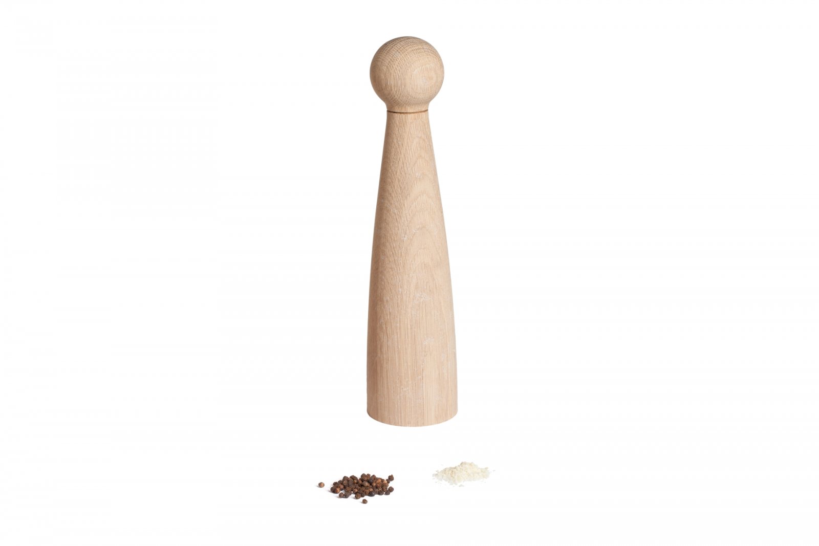 Eine Pfeffermühle aus Holz mit robustem Keramikmahlwerk steht auf weißem Hintergrund, umgeben von schwarzen Pfefferkörnern und frisch gemahlenem Pfeffer.